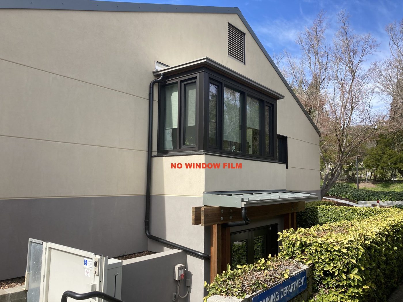 Building exterior showing windows with and without solar control window film