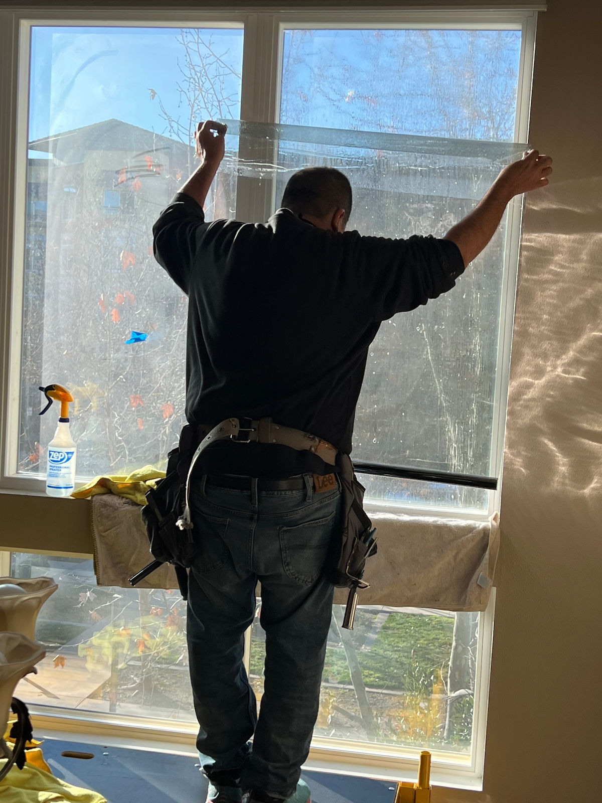 Low Price Window Tint Technician Tinting a Residential Window