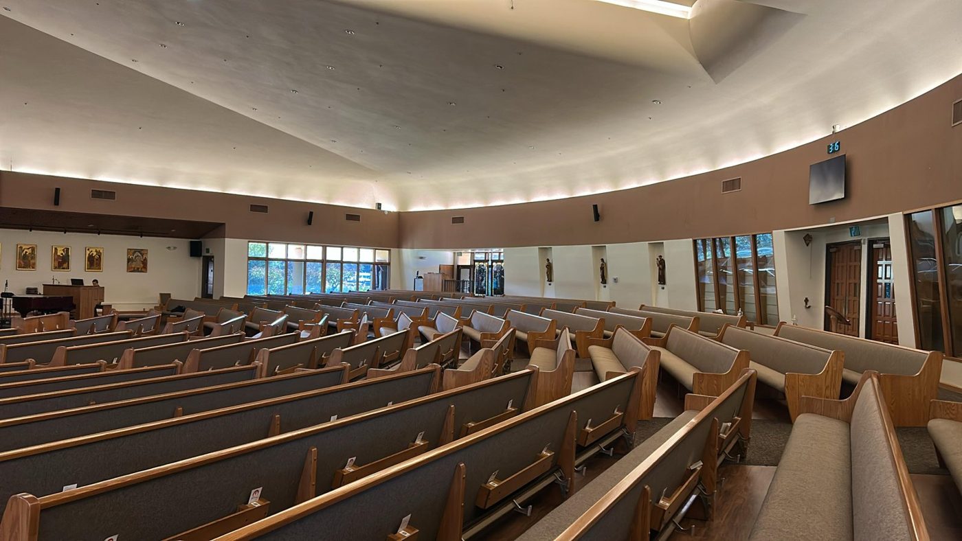 Interior of a church with tinted windows behind the altar