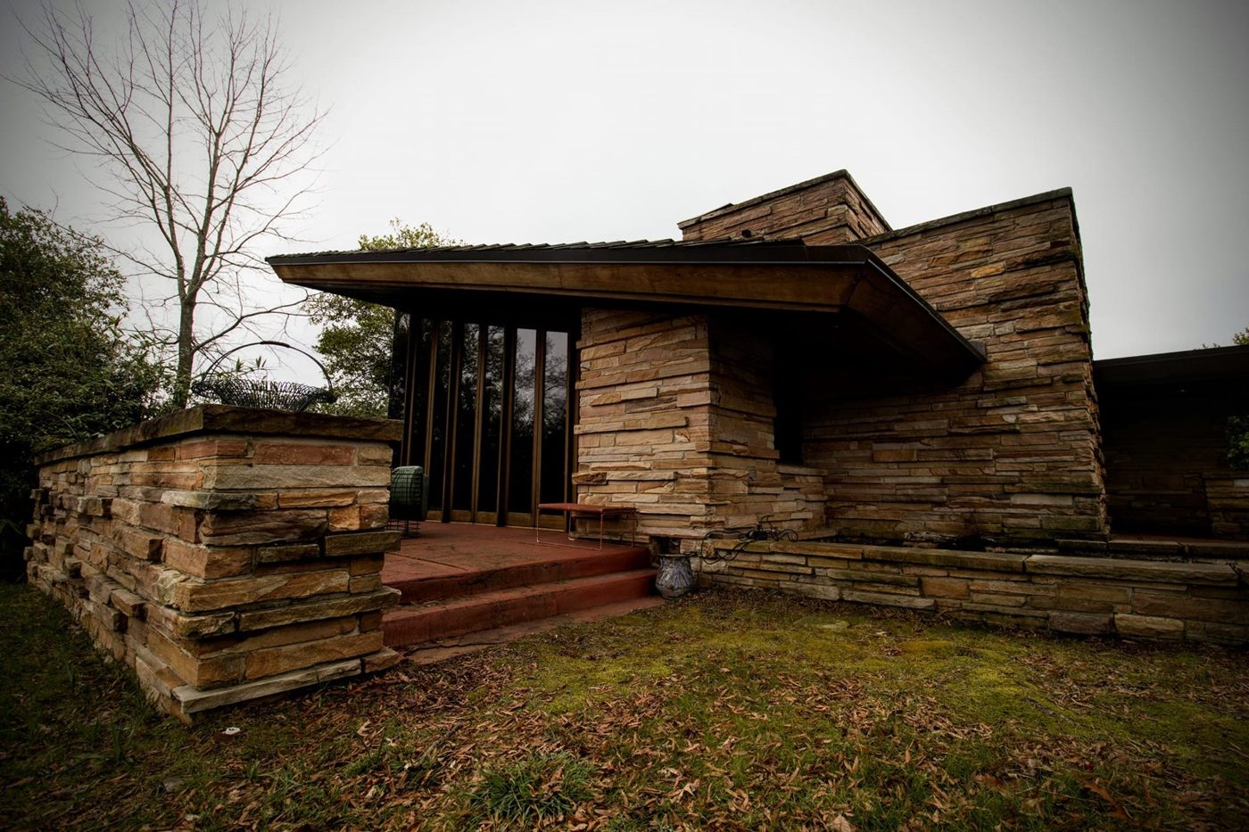Contemporary wood and stone home with window film on the large glazing